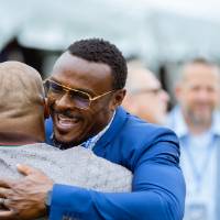Two guests hugging on the field at the Jamie Hosford Football Center dedication.